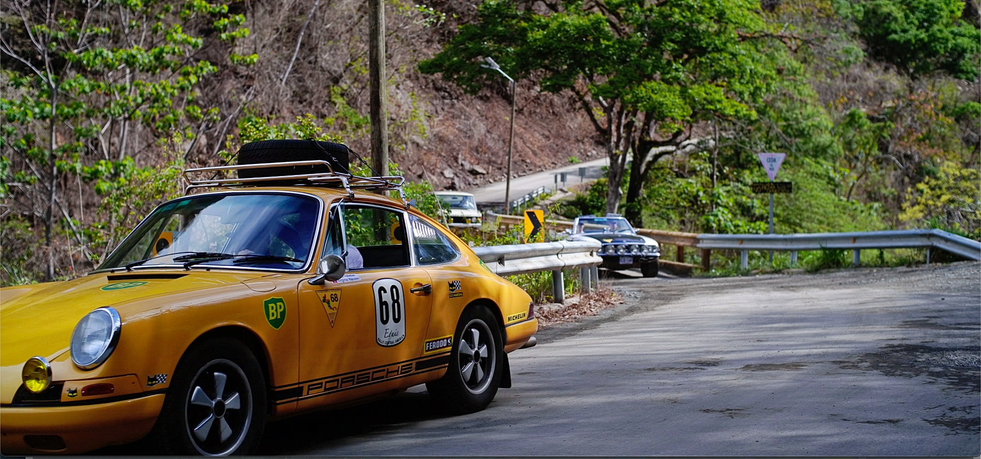 Classic car enthusiasts between dream beaches and high mountains